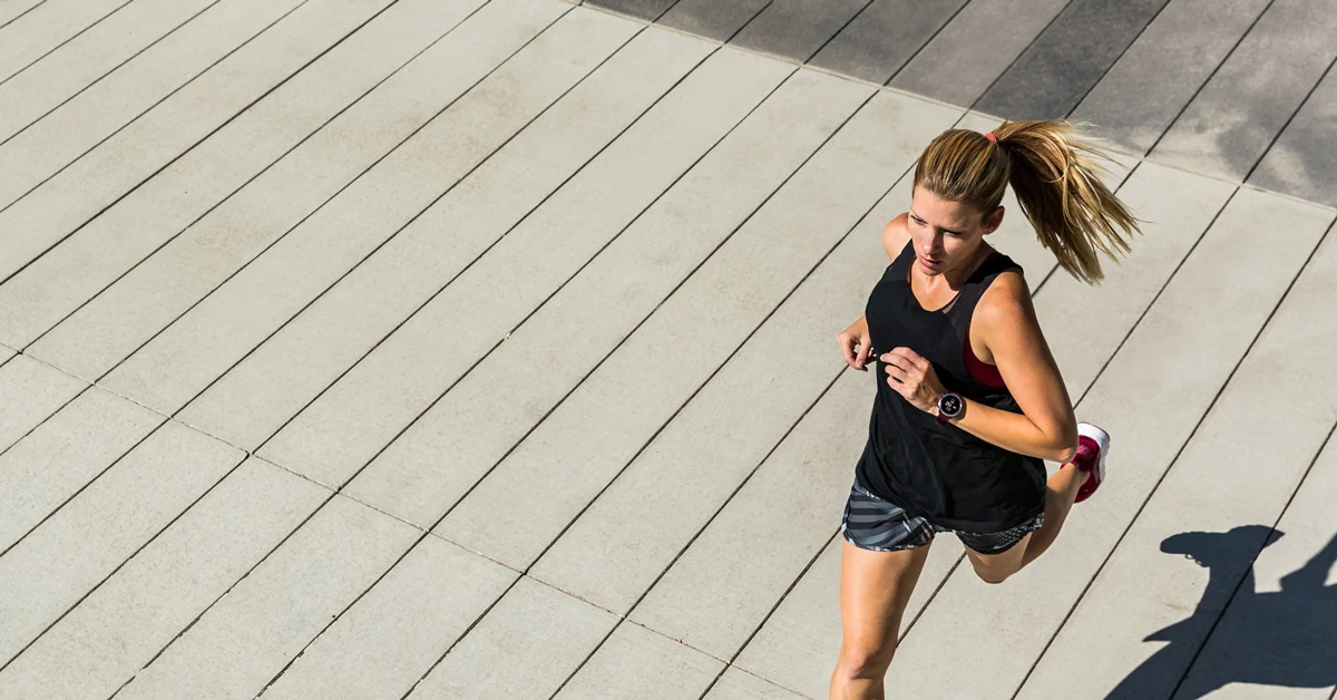 Woman running with Garmin smartwatch